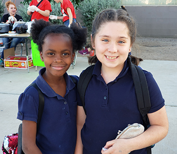 Two happy WVES school girls in navy shirts